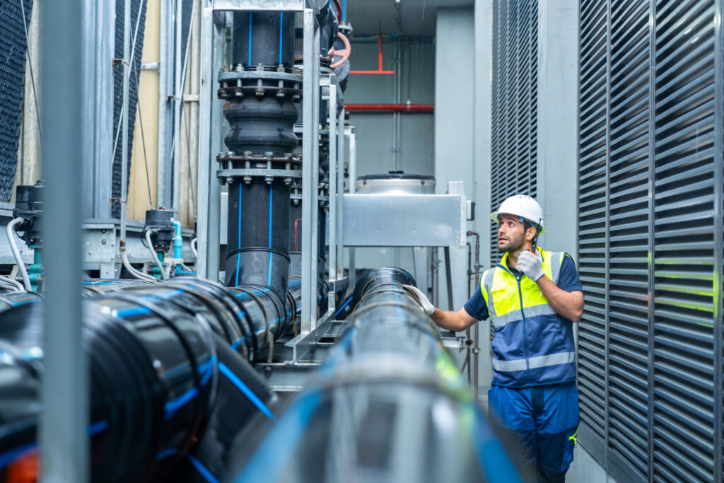 Ingénieur en gilet de sécurité inspectant des équipements industriels de précision dans l'usine Defontaine.