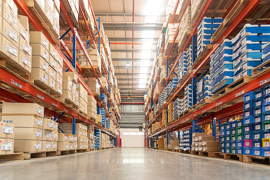 Alignement de rayonnages de stockage et de palettes de produits électroniques dans un grand entrepôt logistique Exertis.